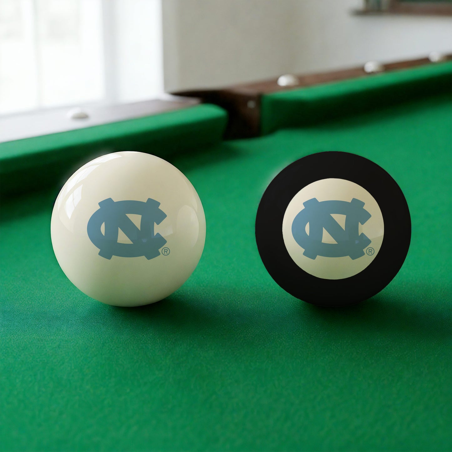 Official North-Carolina-Tar-Heels-Pool-Cue-8-Ball-Set College Cue Ball and 8-Ball Set Displayed Together on Green Felt Pool Table Surface