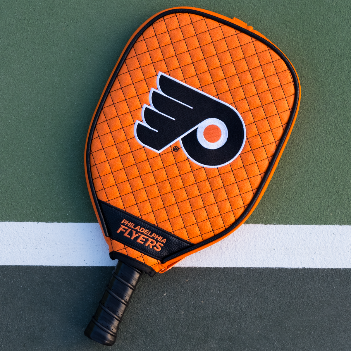 Philadelphia Flyers Orange quilted pickleball paddle cover on court