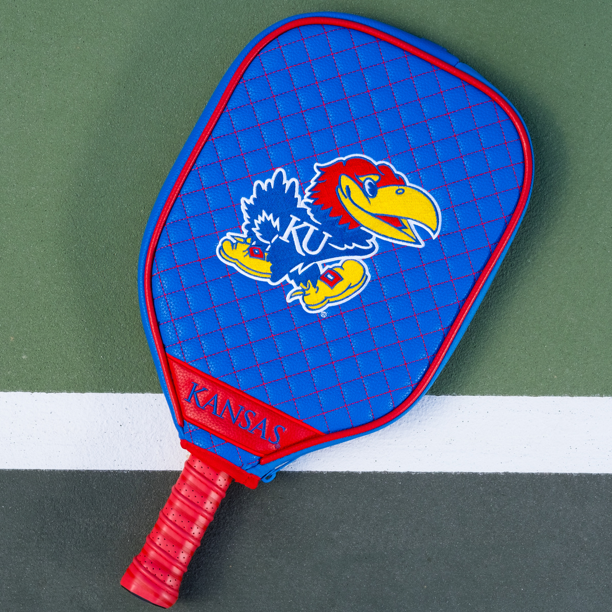 Kansas Jayhawks Blue quilted pickleball paddle cover on court