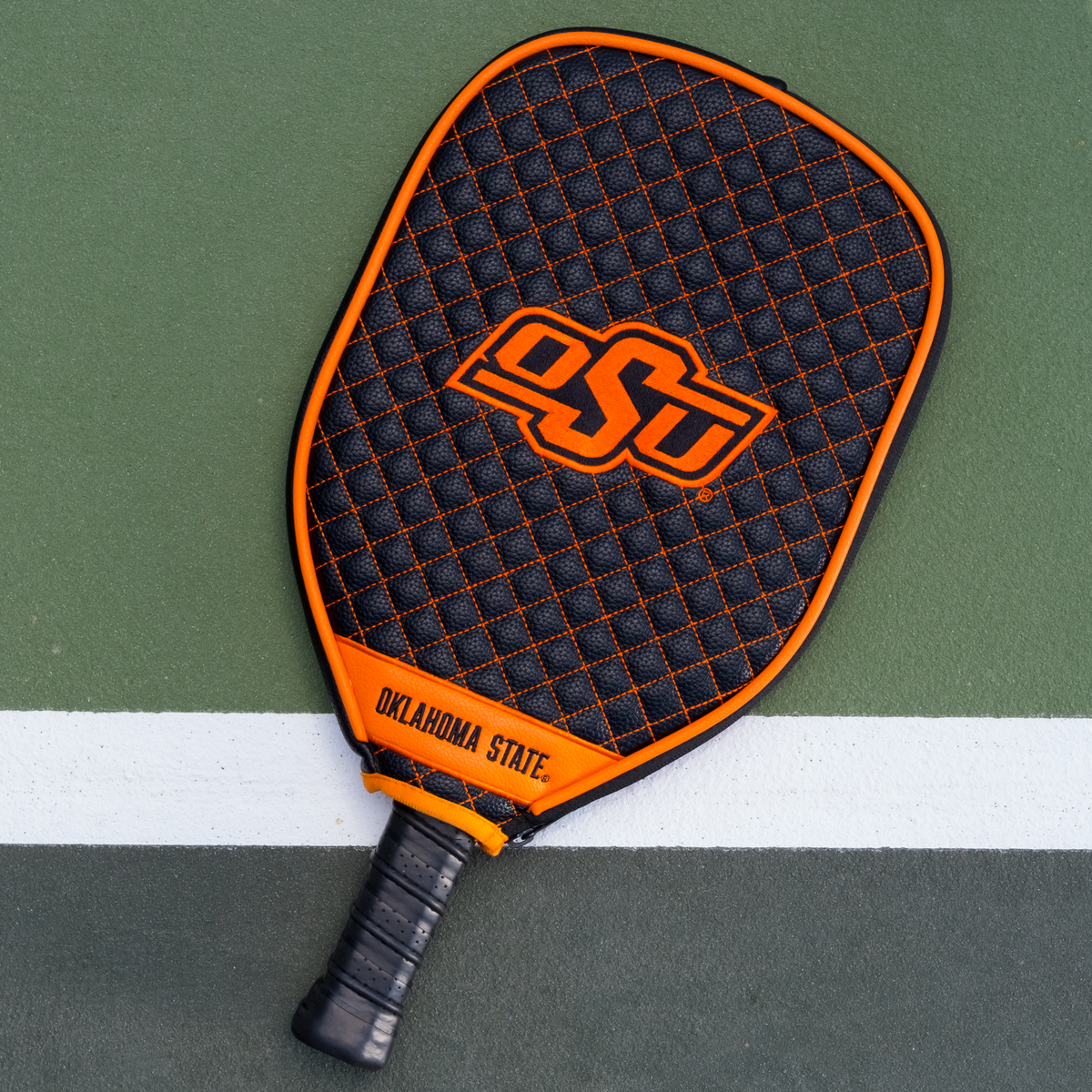 Oklahoma State Cowboys quilted pickleball paddle cover on court view