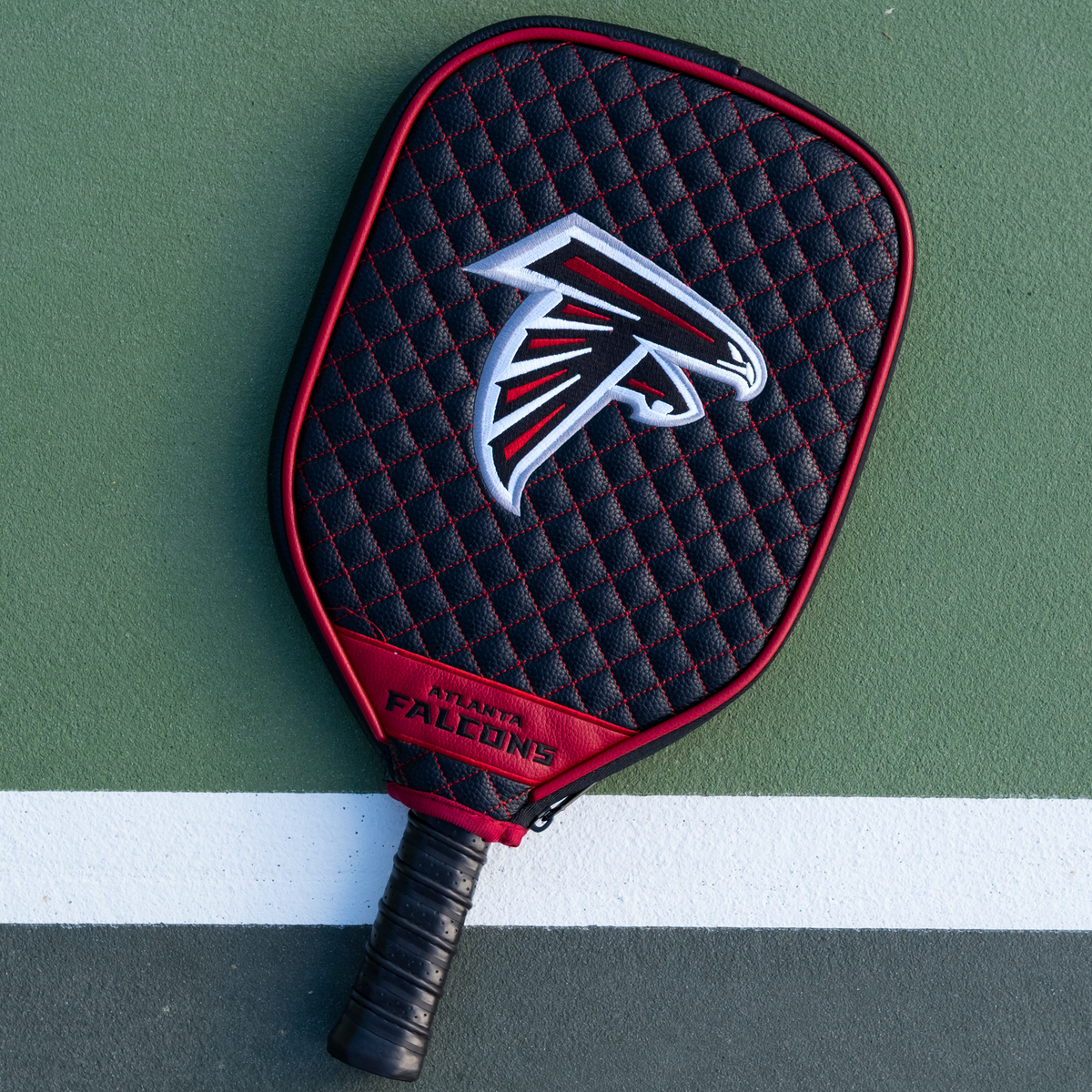 Atlanta Falcons quilted pickleball paddle cover on court view