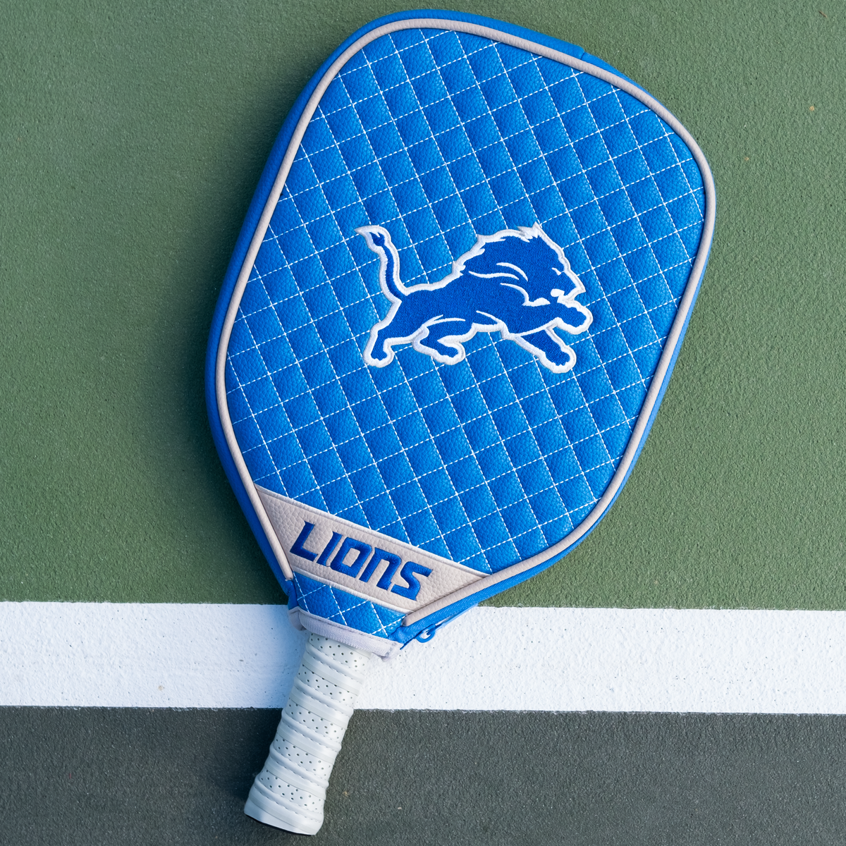 Detroit Lions quilted pickleball paddle cover on court view