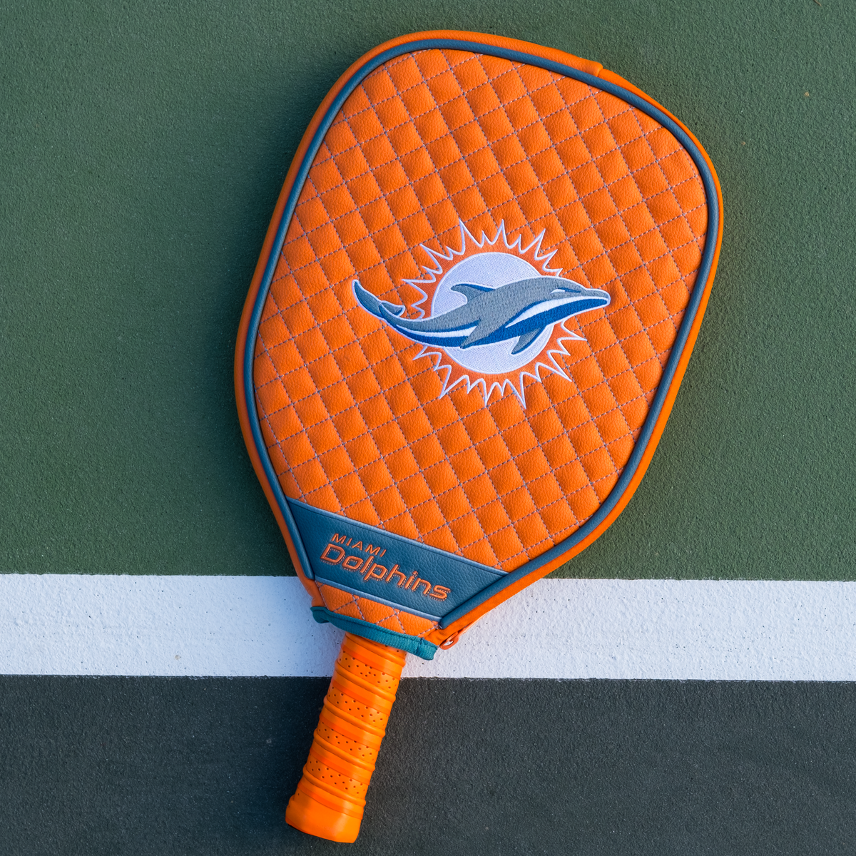 Miami Dolphins Orange quilted pickleball paddle cover on court