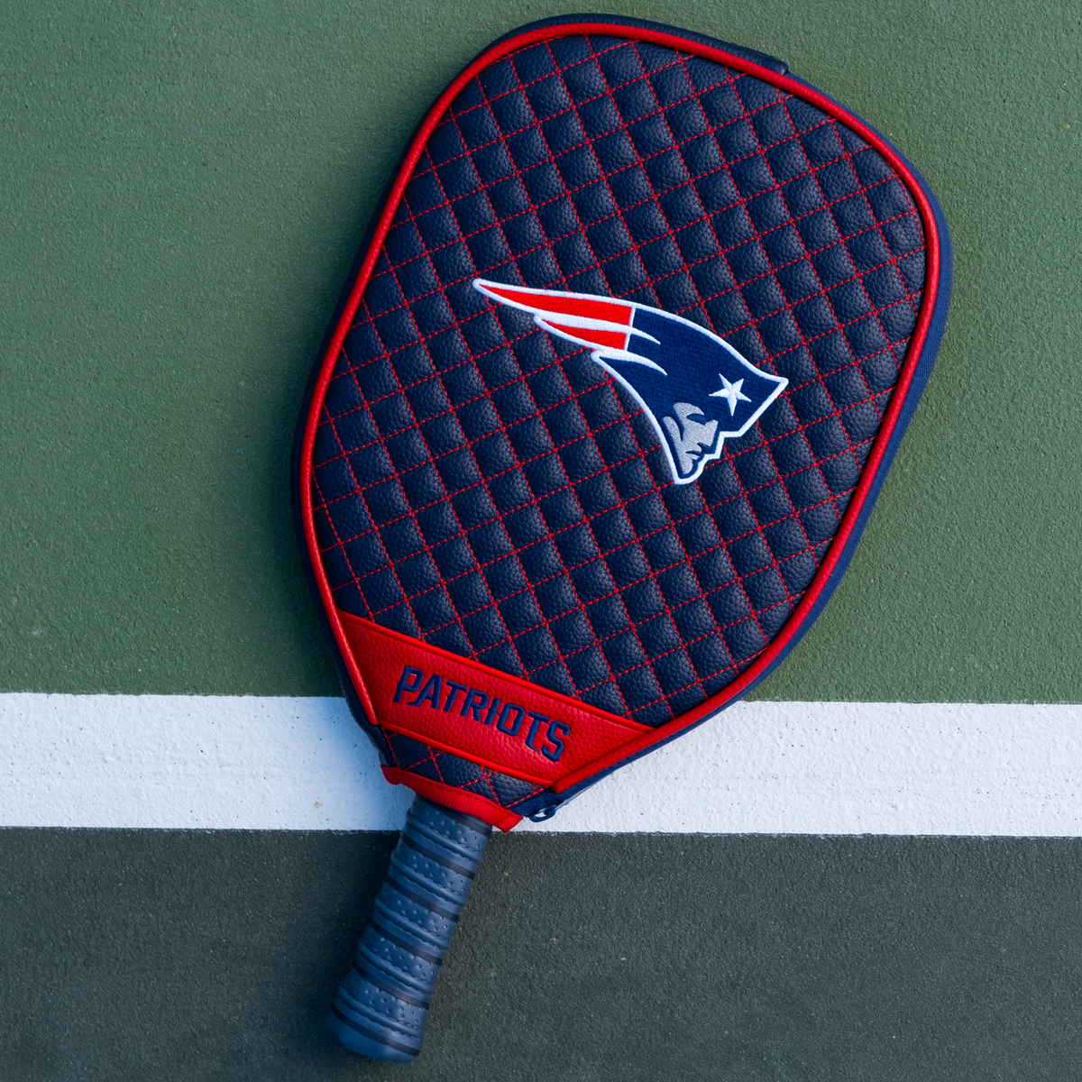 New England Patriots Navy quilted pickleball paddle cover on court