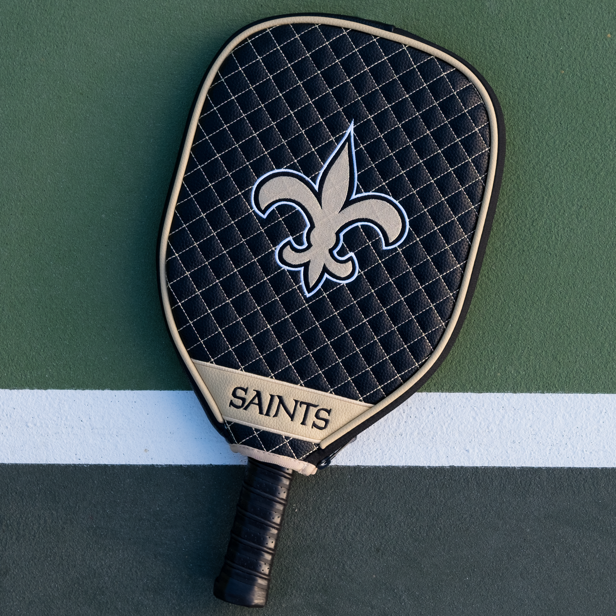 New Orleans Saints quilted pickleball paddle cover on court view