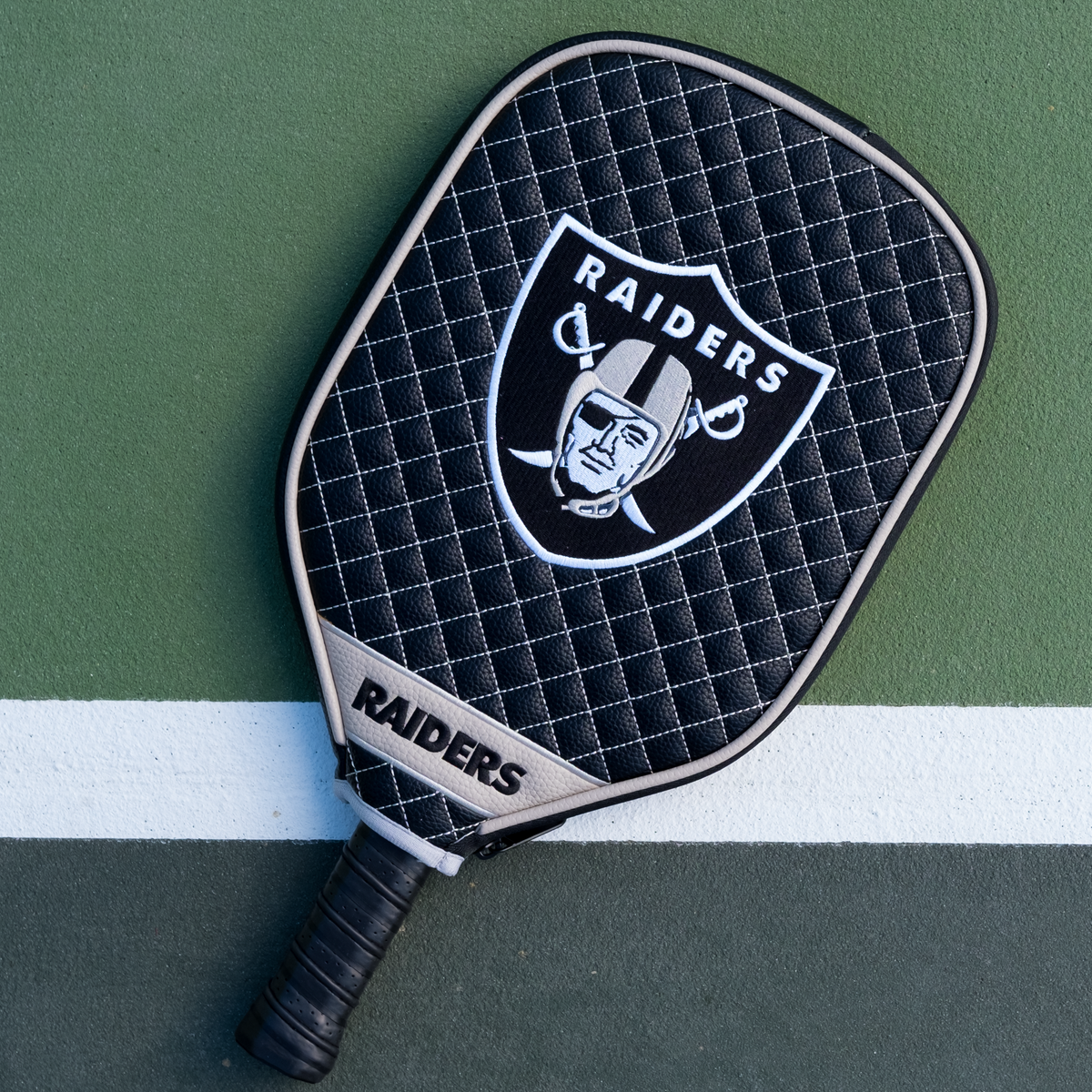 Las Vegas Raiders Black quilted pickleball paddle cover on court