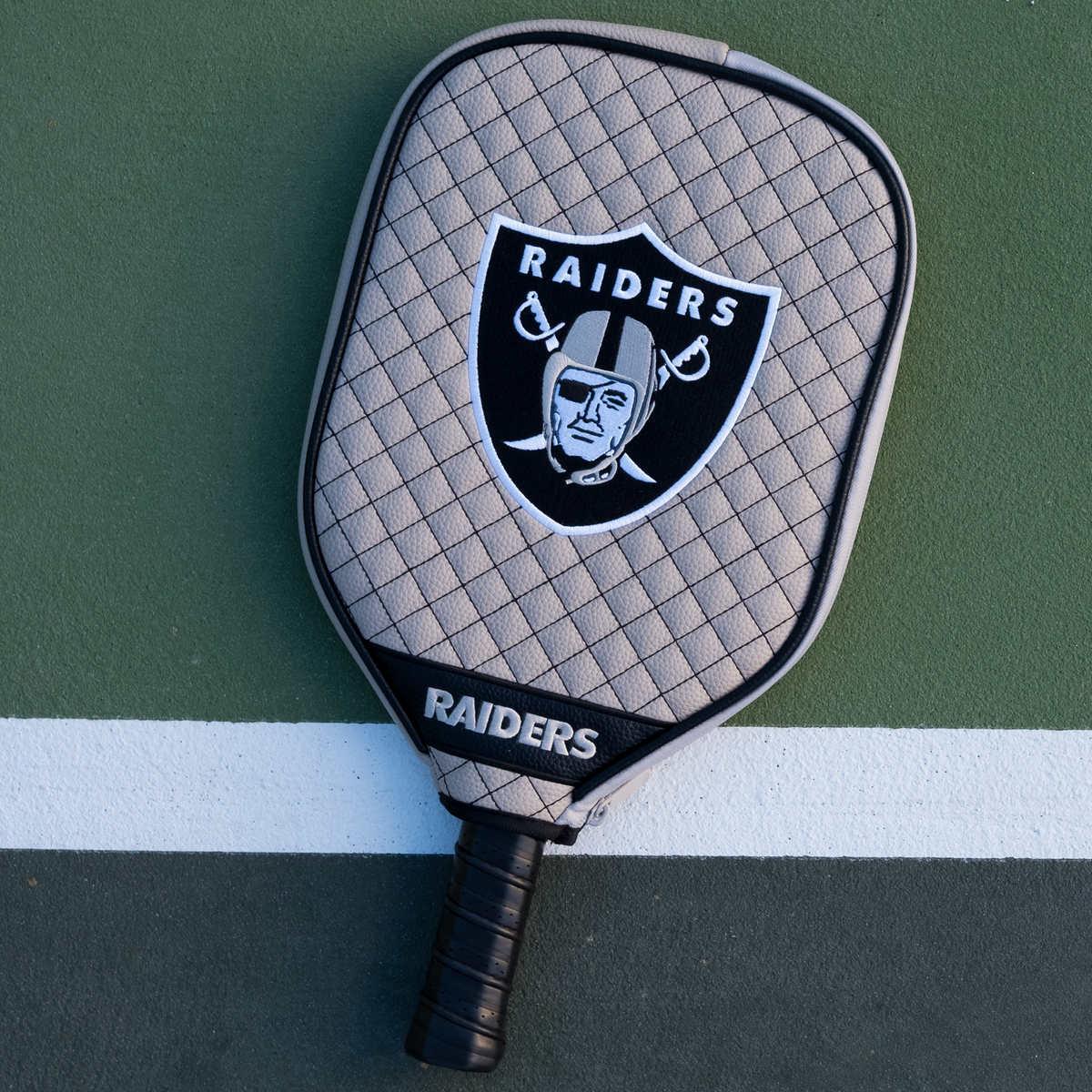 Las Vegas Raiders Silver quilted pickleball paddle cover on court